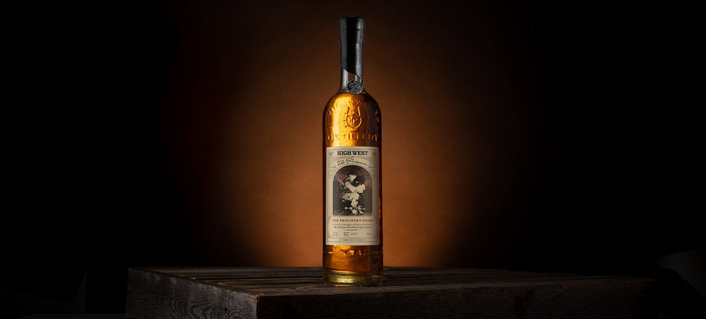 bottle of the prisoners share whiskey on a wooden crate on a brown background